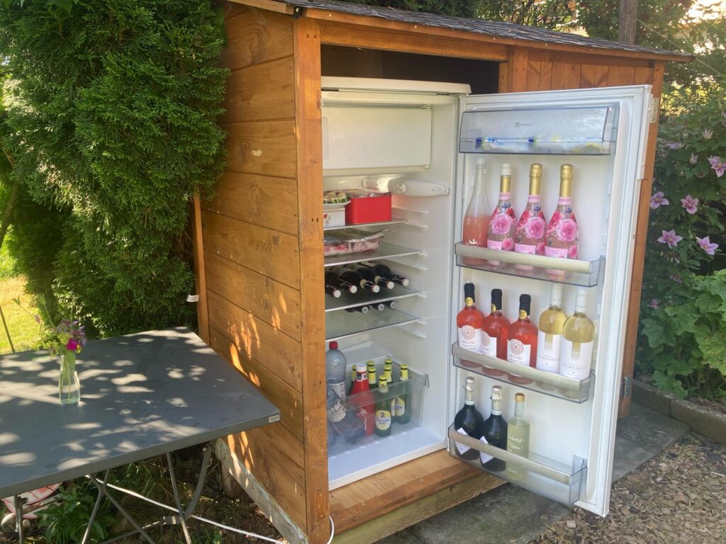 Aussenkühlschrank gefüllt mit Getränken im Garten