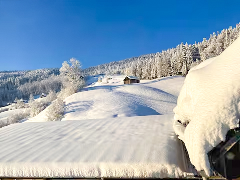 Winterlandschaft mit viel Schnee und blauem Himmel